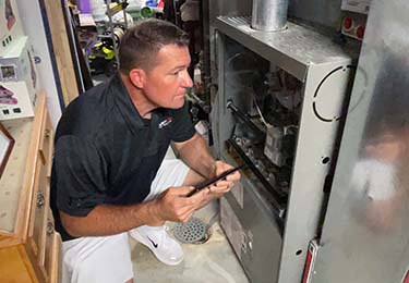 Todd Mayer, licensed home inspector in St. Louis, inspecting a furnace.